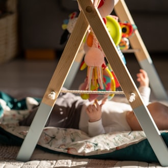 Baby exploring a wooden activity gym during tummy time
