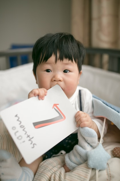 Infant holding a milestone card during a quiet moment