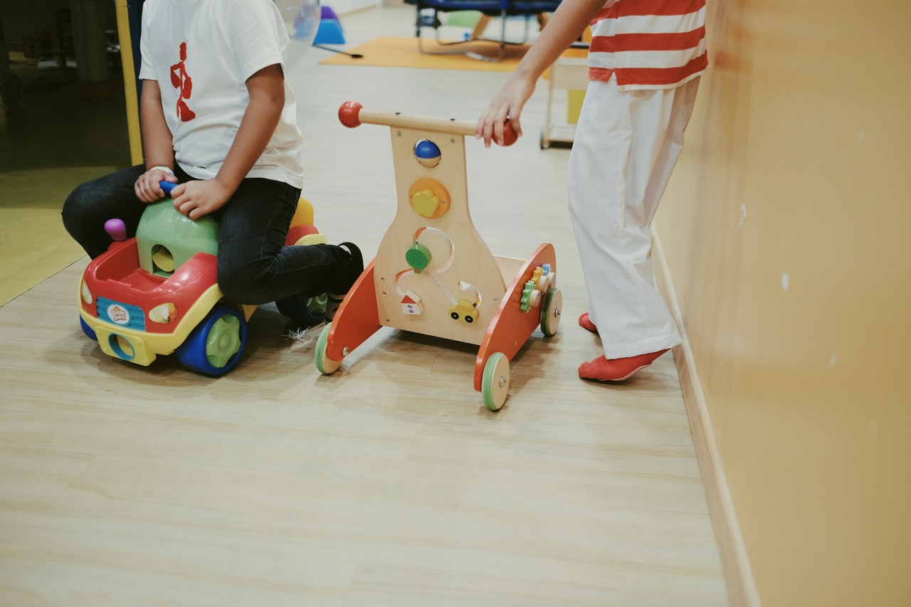 Young children playing with push toys and ride-ons