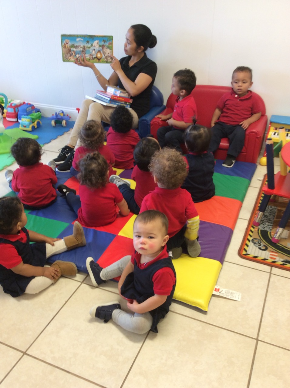 A teacher reading a picture book to children gathered for circle time