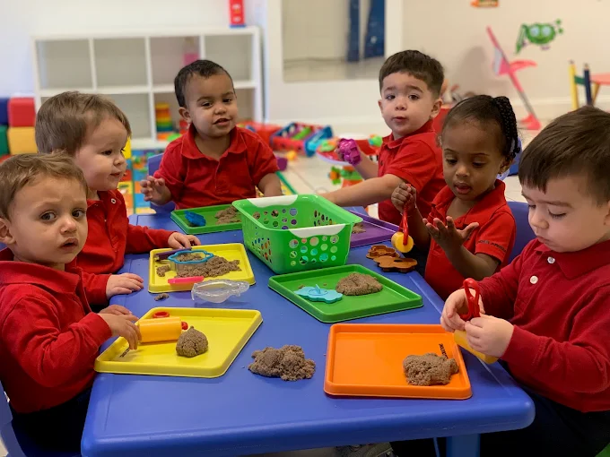 Children working together at a classroom table during a hands-on activity at Malave Child Care Center